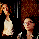 Delphine approaches Cosima from behind and kisses her