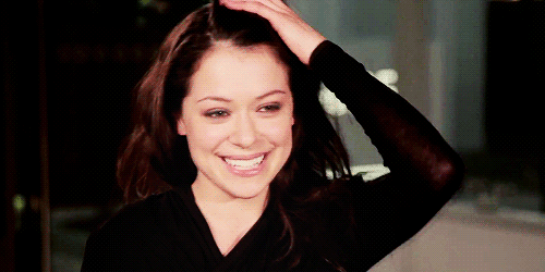 Tatiana Maslany smiles and runs her hand through her hair