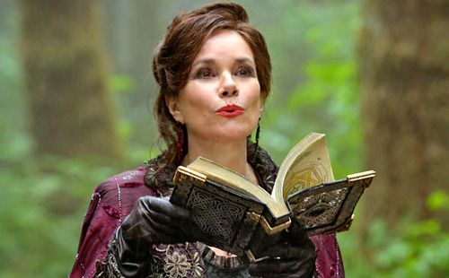 Cora is holding an open book and appears to be sayinging something, presumably she is casting a spell