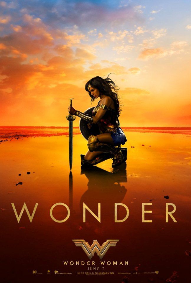 New Wonder Woman poster shows Wonder Woman kneeling down on a sunset beach staring at her sword which she is pointing directly at the sand