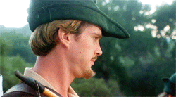 Carey Elwes as Robin Hood looking turning his head with a flat look on his face.
