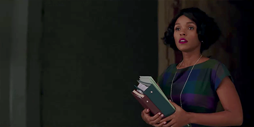 Mary Jackson carrying a stack of books and paper binders