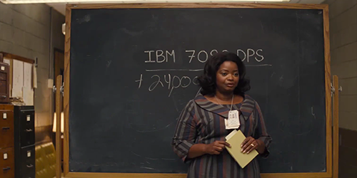 Dorothy Vaughan standing in front of a freestanding chalkboard